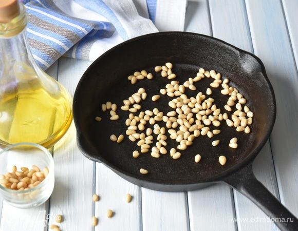 Половину кедровых орешков поджарить. При обжаривании орехи выделяют масло и придадут песто аромат. Часть орехов не обжаривать, они придадут песто кремообразную текстуру.