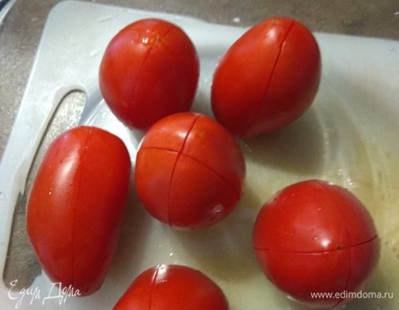 Сначала подготовим помидоры. Моем, делаем продольные надрезы и заливаем кипятком на минуту.