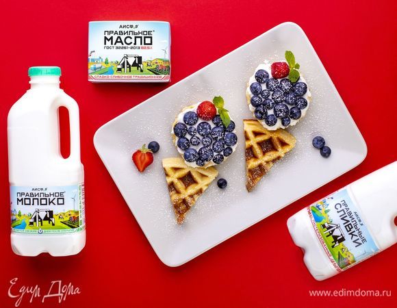 Смажьте сливками вафельные кружочки, сверху положите чернику и клубнику. Такое угощение понравится детям!<br />
 