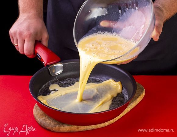 Вылейте яично-молочную смесь. Жарьте омлет на среднем огне 3 минуты, затем накройте крышкой, убавьте огонь до минимального и томите до готовности.