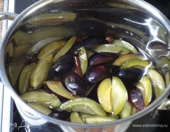 Пока корж выпекается и остывает, приготовим сироп. В кастрюле смешайте сахар с водой. Помешайте до растворения сахара, доведите до кипения и, не перемешивая, поварите 2 минуты. Добавьте специи и нарезанные на 4 части сливы, потомите на медленном огне под крышкой 10 минут. Аромат — не передать словами!