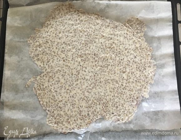 Разделите тесто на две части. Два листа пергамента смажьте оливковым маслом и раскатайте между ними каждую часть теста в тонкий пласт толщиной 3 мм. Уберите верхний пергамент и перенесите тесто с нижним листом бумаги на противень.