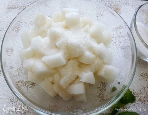 Дыню нарезать на кусочки, засыпать сахаром и оставить на полчаса до выделения сока.