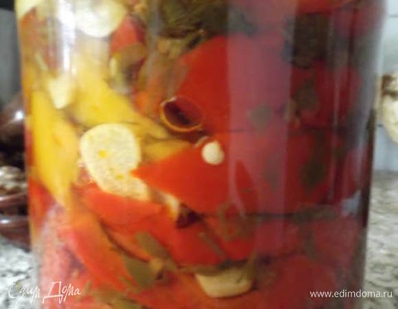 3 кг перца почистить и нарезать произвольно. 4–5 головок чеснока почистить и нарезать пластинами. Зелень петрушки и укропа мелко порубить. Сварить рассол: вода + сахар + соль + растительное масло + уксусная эссенция. В кипящий рассол добавить чеснок и варить 5 минут. Добавить перец и зелень. Кипятить 15 минут. Закатать в стерилизованные банки.