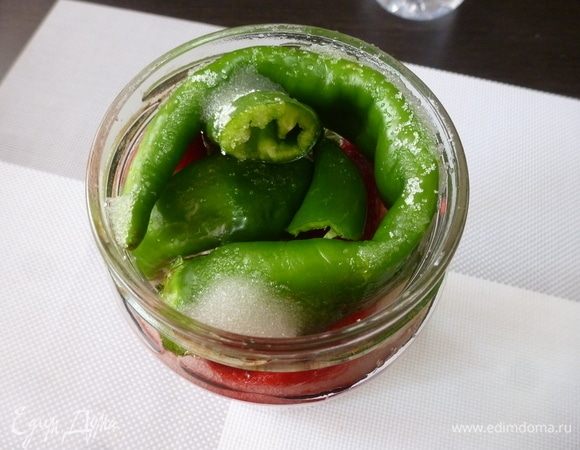 Прикройте крышкой и оставьте на 10–20 минут. В проколы перчиков проникнет маринад, перец осядет, и уксуса нужно будет долить еще. Через несколько часов сахар вытянет сок из перчиков, и они как бы съежатся. Поэтому можно будет добавить еще 2–3–4 перчика. Закрываем крышкой и отправляем баночку в холодное место (у меня холодильник) на хранение.