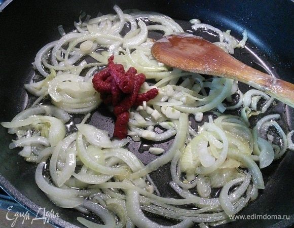 В сковороду добавить еще оливкового масла и пассеровать лук и чеснок до прозрачности. По желанию можно добавить острый перец чили. Добавить томатную пасту и обжаривать в течение минуты.