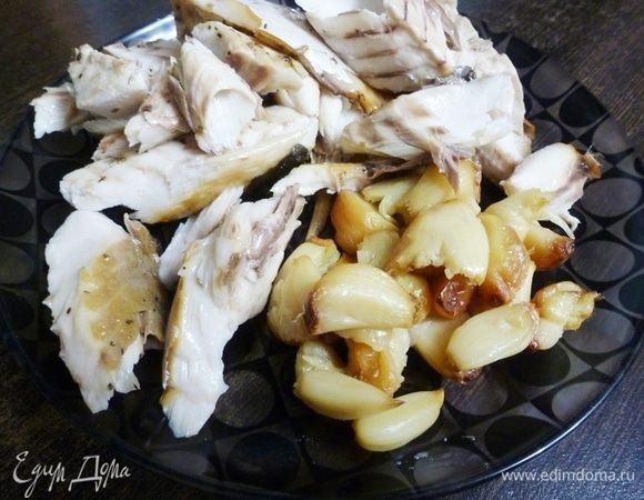 Запеченную рыбу разобрать на филе, стараясь вытащить все косточки. Из зубчиков чеснока выдавить запеченную мякоть.