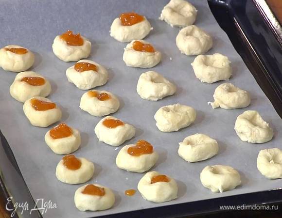 В углубления выложить понемногу абрикосового джема и выпекать печенье в разогретой духовке 12–15 минут.