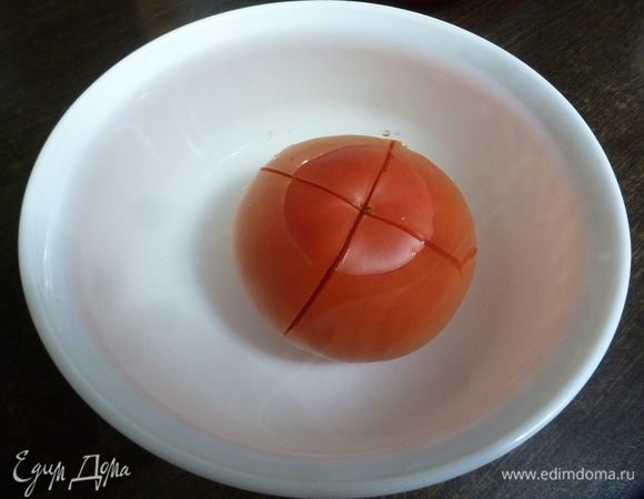 Помидоры надрезать сверху и залить кипятком на полминуты, затем обдать холодной водой. Снять шкурку.