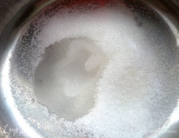 В кастрюлю с толстым дном насыпать сахар и добавить немного воды.