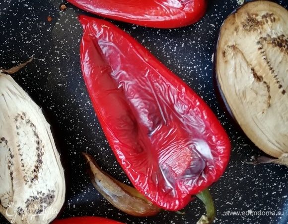 Перцы и баклажаны запекаем в духовке при 300°С в течение 20 минут. С готовых перцев снимаем шкурку и очищаем их от семян. У перца чили семена оставляем. Баклажан очищаем от шкурки.