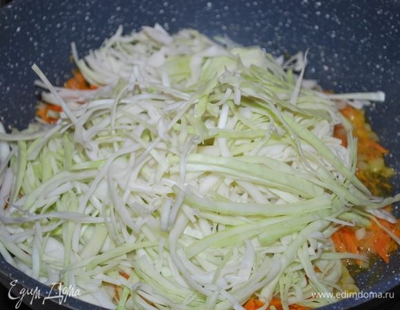 К обжаренной моркови с луком добавляем нарезанную капусту и обжариваем все вместе 5–7 минут.
