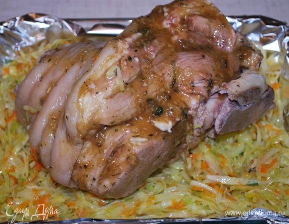 Отваренную рульку выкладываем на капусту, смазываем соусом. Капусту прикрываем фольгой, чтобы не пригорела. Ставим все в духовку, разогретую до 200°C, на 20 минут для запекания.