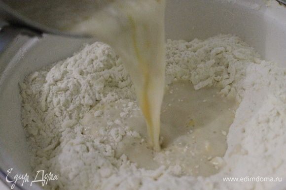 Сделать лунку и влить в муку с маслом жидкую молочно-дрожжевую смесь. Замесить тесто. Завернуть его в пленку и отправить в холодильник на 1 час. Затем оставить тесто при комнатной температуре на 15–20 минут.