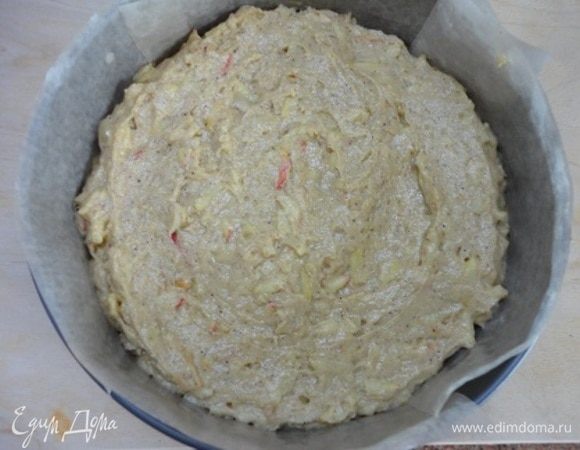 Форму диаметром 24 см смазать маслом и посыпать манной крупой или сухарями. Я обычно застилаю бумагой. Тесто выложить и разровнять.