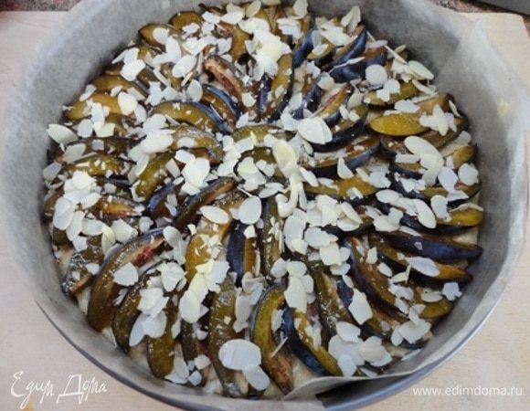 Сверху плотно выложить сливу и посыпать миндальными лепестками. Выпекать 40–45 минут при температуре 190°C.