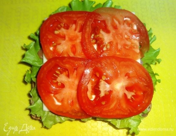 На сыр выложить кружки помидоров.