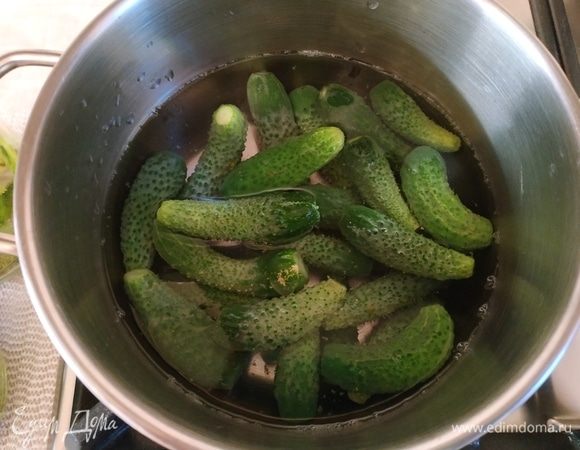 Опускаем партиями корнишоны в горячий уксус, держим огурчики секунд 30 и достаем их.