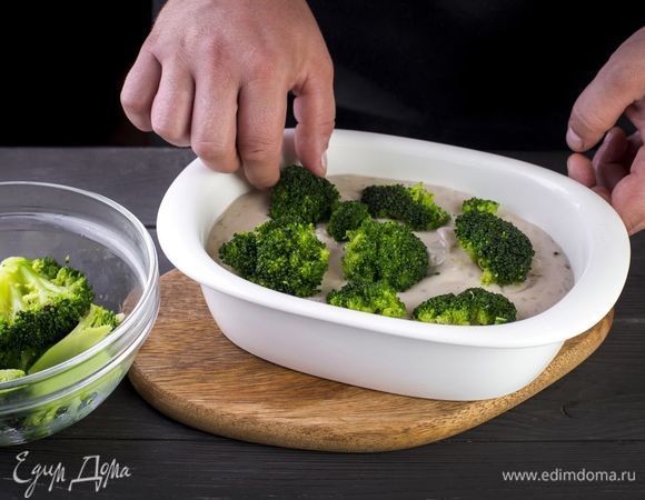 Подготовьте форму для запекания. Переложите в нее куриное филе и сверху отварные брокколи.