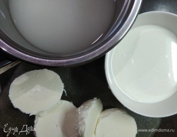 Берем крупные шарики моцареллы. Также нам понадобится не только сам сыр моцарелла, но и сыворотка, в которой он хранится. Сливки нужны охлажденные. Итак. Берем небольшую кастрюлю, вливаем в нее сыворотку, добавляем соль и ставим на огонь. Здесь хочу добавить, что количество соли можно увеличить по своему вкусу, а еще добавить свои любимые травы и специи. Но, конечно, это всегда можно сделать и при дальнейшем приготовлении блюд с уже готовым продуктом. Сыр режем пополам и опускаем в кастрюлю.