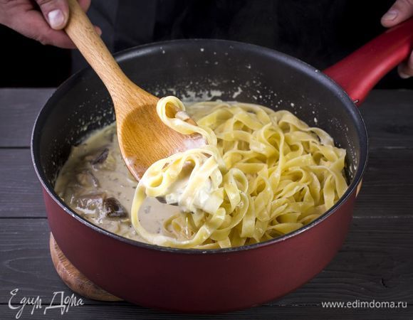 Положите феттучине в сковороду. Перемешайте аккуратно.