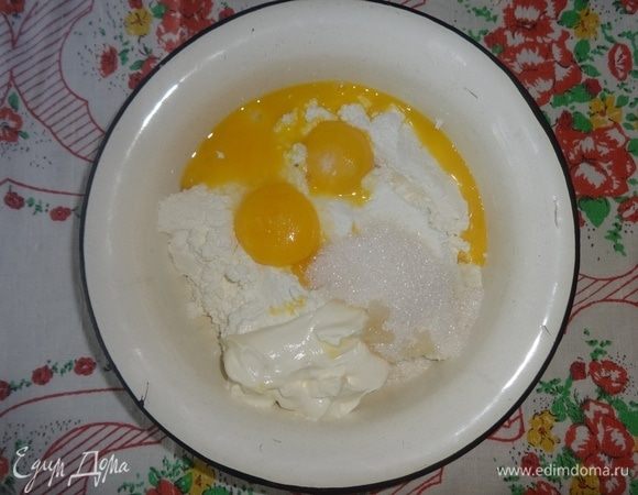 В протертый творог добавить желтки, сметану, разрыхлитель, сахар. Перемешать.