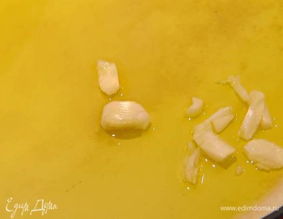 Разогреть в сковороде с огнеупорными ручками оливковое масло и выложить чеснок.