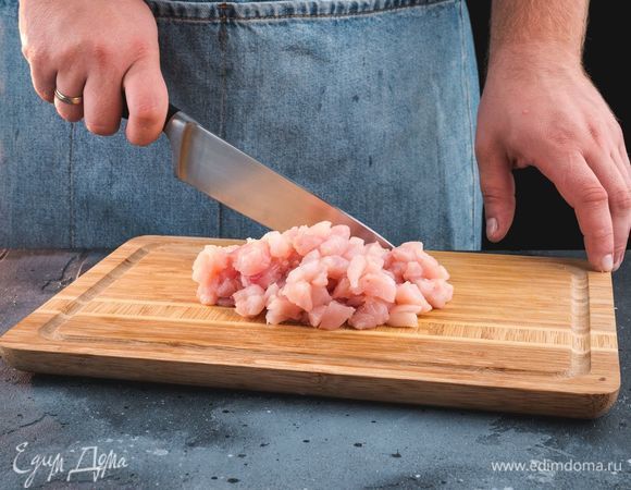 С помощью острого ножа нарубите подготовленное куриное филе на мелкие кусочки.