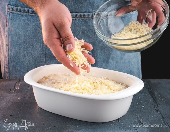 Форму для запекания смажьте сливочным маслом и выложите в нее массу. Посыпьте сверху тертым сыром.