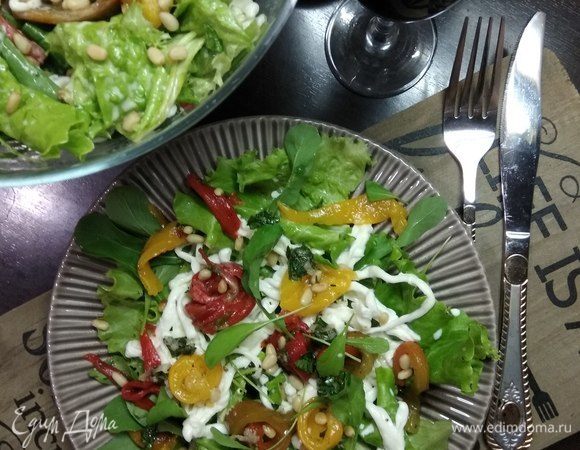 Собираем салат. Если порционно: на микс из салатных листьев и руколы выкладываем в хаотичном порядке полоски перца, нити страчателлы, поливаем заправкой и посыпаем кедровыми орешками. Либо подаем в большом салатнике, перемешав все ингредиенты. Приятного аппетита!