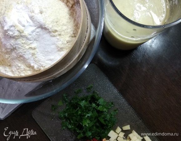 Режем сыр кубиками, измельчаем острый перец (любители острого могут увеличить его количество) и зелень. Разогреваем духовку до 180°C. Смешиваем сыворотку с яйцами и маслом. В отдельную посуду просеиваем оба вида муки, разрыхлитель, соду, добавляем соль и сахар.