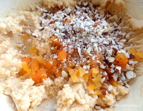 Добавить орехи и курагу в тесто.