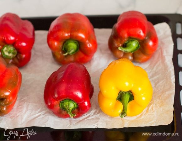 Вымыть перцы и уложить их на противень, застеленный бумагой для выпечки.