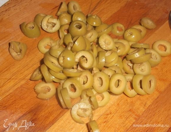 Оливки нарезать. Рассол из банки вылить в бульон.