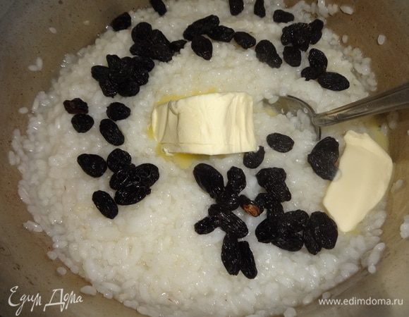В полуготовый рис кладем изюм, сливочное масло, перемешиваем все и снимаем с огня.