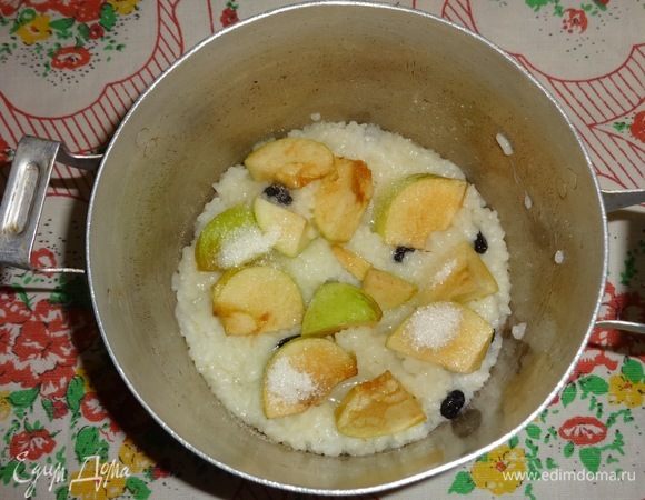 В кастрюльку выложить слой риса с изюмом, положить слой яблок и посыпать 1 ст. л. сахара. Далее продолжать чередование: рис, яблоки, сахар.