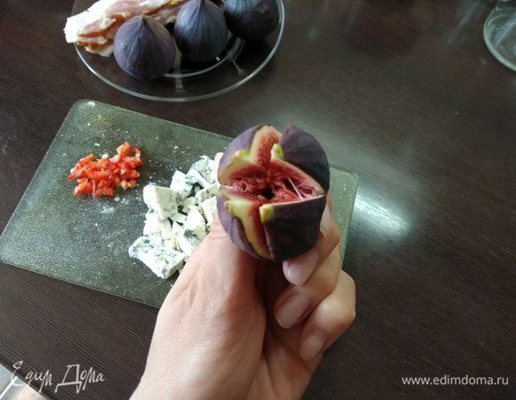 Инжир разрезаем крест-накрест. Сдавливаем основание плода так, чтобы он раскрылся, и фаршируем его сырными кусочками.