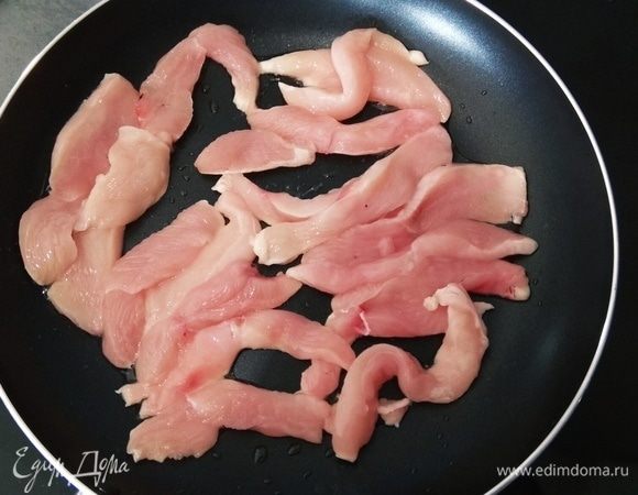 Куриное филе нарезаем ломтиками, выкладываем на разогретую сковородку, солим и жарим до золотистого цвета.
