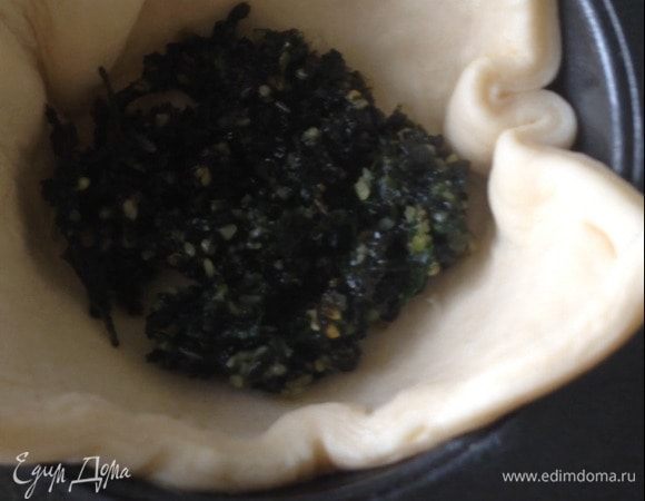 Положить по столовой ложке соуса песто, сверху — кусочки нарезанных томатов, затем распределить сыр моцарелла.