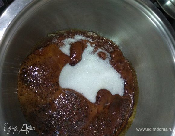 Варим первую карамель, в которой будут запекаться персики. Приготовление этого тарта предполагает варку карамели в той же форме, в которой будет потом запекаться пирог. Идеально подойдет сковорода с высокими бортами и диаметром 24 см. За неимением таковой берем кастрюлю с толстым дном, насыпаем туда 200 г сахара и ставим на слабый огонь. Не мешаем, не трогаем, просто ждем, когда сахар начнет карамелизироваться. После того, как около 2/3 сахара расплавится, можно приподнять кастрюлю и наклонить ее несколько раз в разные стороны, как бы скрывая под карамелью оставшийся белый слой. После того, как он исчезнет, берем лопатку и перемешиваем жидкость до получения однородной массы и полного растворения кристалликов.