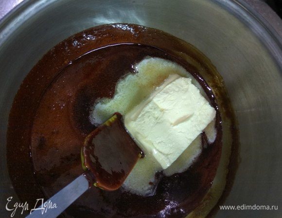 Затем снимаем карамель с огня и добавляем 100 г сливочного масла комнатной температуры, тщательно перемешиваем, даем карамели остыть.