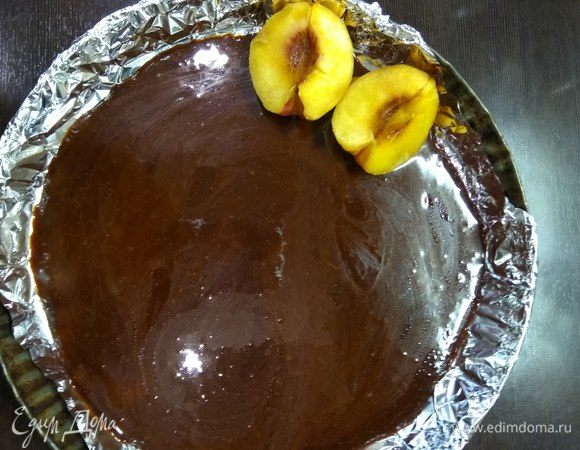 Ставим духовку на разогрев до 190°C. В глубокую форму (лучше с высокими бортами и неразъемную) выливаем карамель и укладываем персики срезом вверх по кругу, стараясь выложить фрукты плотнее. У меня была только разъемная форма, поэтому я застелила ее фольгой, чтобы жидкость не просочилась в процессе выпекания.