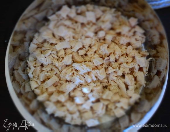 На дно формы выложить в один слой нарезанную грудку. Смазать майонезом.