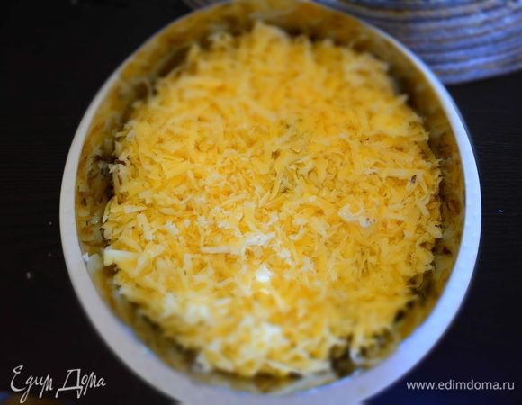 Следующим слоем выкладываем натертый на мелкой терке сыр. Смазываем майонезом.