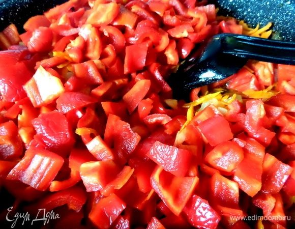 Перец болгарский нарезать кусочками, чили измельчить. Высыпать перцы к обжаренным овощам.