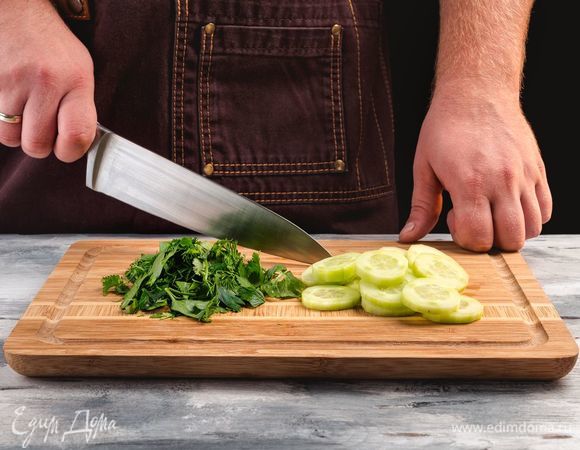 При необходимости порвите листья салата. Удалите кожуру с огурцов и нашинкуйте тонкими кольцами. Порубите мелко зелень.