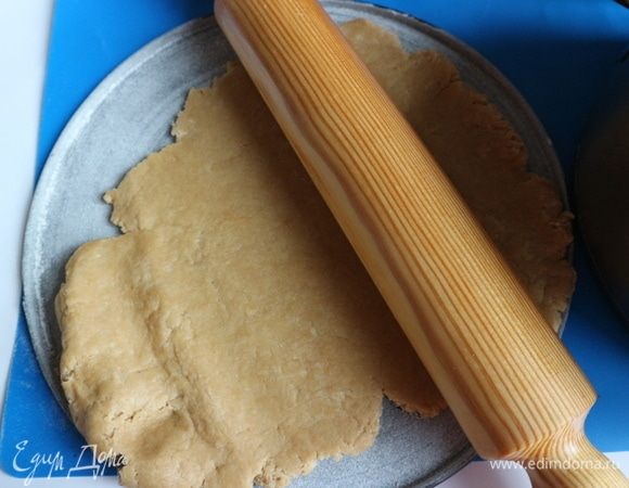 Тесто раскатать на донышке формы, расправить руками, одеть бортик формы, сделать небольшие бортики из теста. Если вы возьмете форму диаметром 28 см, как у меня, то получите довольно тонкий слой теста.