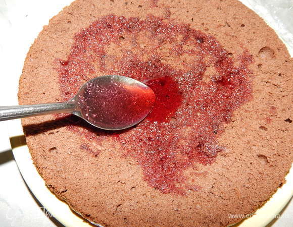 Приступаем к сборке торта. На середину подставки для торта выложить немного крема. Положить корж, пропитать его вишневым сиропом (вишню из сиропа выложить).