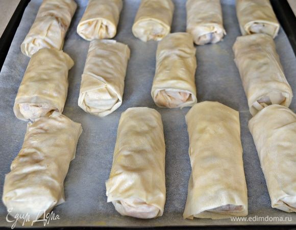 На каждую часть уложите по 1 ст. л. с верхом начинки и аккуратно сверните трубочкой, подворачивая боковые края. Сверху смажьте растопленным сливочным маслом или, по желанию, яичным желтком. Выпекайте трубочки при 200 г до золотистого цвета (примерно 40 минут).