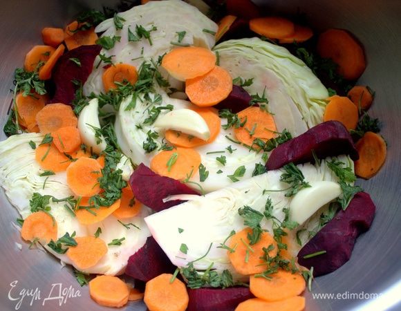 Насыпать кружочки моркови и сырую свеклу с зеленью и чесноком — это будет первый слой.